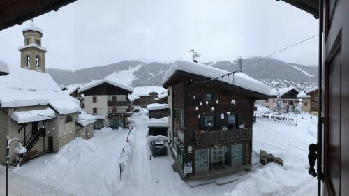 a town covered in snow with a church at Garni La Casetta in Livigno