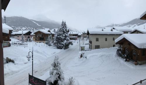 a town covered in snow with trees and buildings at Garni La Casetta in Livigno