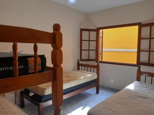 a bedroom with two bunk beds and a window at Casa de férias in Caraguatatuba