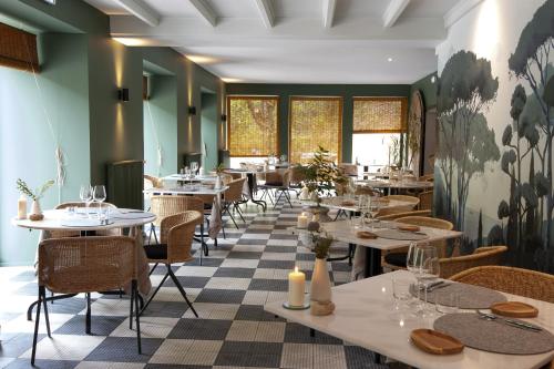 a restaurant with tables and chairs and windows at Le Sahuc in Rivière-sur-Tarn