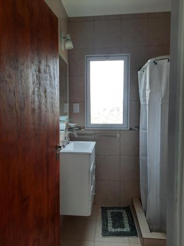 a bathroom with a sink and a window at Las Catalpas in Macachín