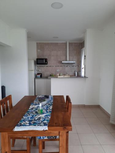 a kitchen with a wooden table with chairs and a kitchen counter at Las Catalpas in Macachín