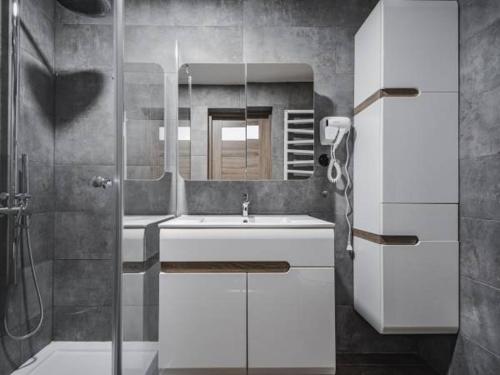 a bathroom with a sink and a mirror at Apartamenty Góralska Pasja Krupówki 37 in Zakopane