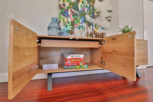 a wooden cabinet with a shelf in a room at Indulge Luxury Homes - Dockside Marina in Mildura