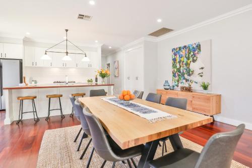 a kitchen and dining room with a wooden table and chairs at Indulge Luxury Homes - Dockside Marina in Mildura