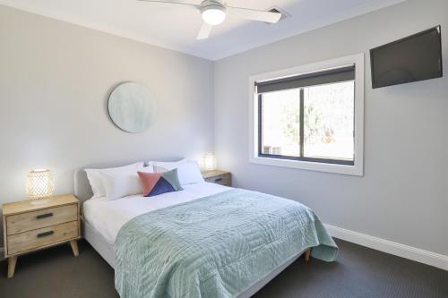 a white bedroom with a bed and a window at Indulge Luxury Homes - Dockside Marina in Mildura