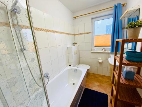 a bathroom with a tub and a toilet and a shower at Residenz Bismarck - Ferienwohnung Maris in Ahlbeck