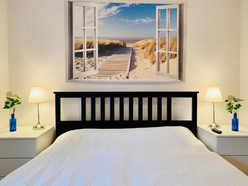 a bedroom with a bed and a picture of a beach at Residenz Bismarck - Ferienwohnung Maris in Ahlbeck