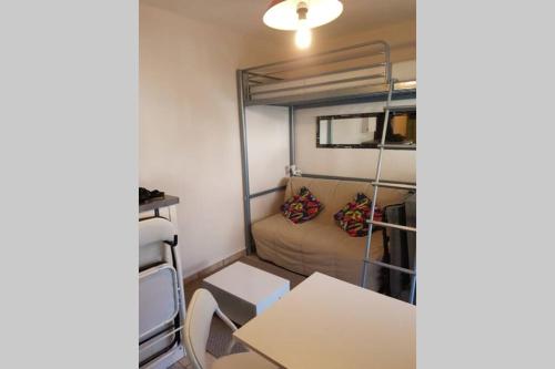 een kleine kamer met een bank en een stapelbed bij Studio idéalement situé in Cauterets