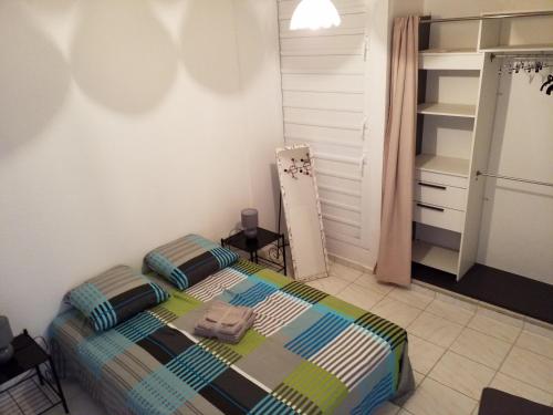 Dormitorio pequeño con cama y armario en Appartement Centre Guadeloupe, accessible et proche en Les Abymes
