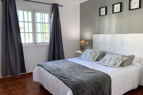 a bedroom with a white bed and a window at Apartamento Bastian Casas Verdes in Costa Teguise