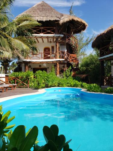 a villa with a swimming pool in front of a resort at Casa Hridaya Hotel Boutique in Holbox Island
