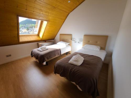 2 camas en una habitación con ventana en Dúplex a la Massana a 25 metres del telecabina de pal 612 en La Massana