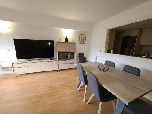 a living room with a dining table and a flat screen tv at Dúplex a la Massana a 25 metres del telecabina de pal 612 in La Massana