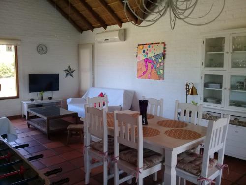 ein Esszimmer mit Tisch und Stühlen und einem Fernseher in der Unterkunft Montoya Jazmin in Punta del Este