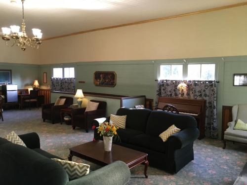 a living room with couches and chairs and a table at Alexander's Lodge in Ashford