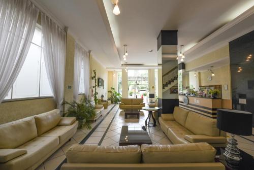 a large living room with couches and a table at Imperador Hotel in Poços de Caldas