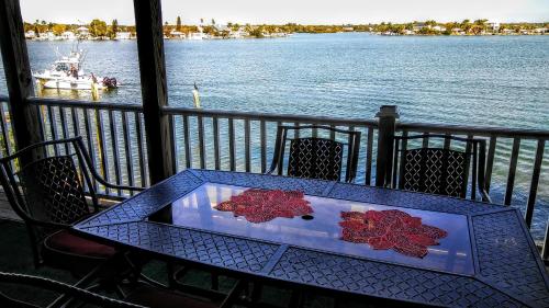 a table on a balcony with a view of the water at 3000 Sq Ft Beach and Bay Condo in St Pete Beach