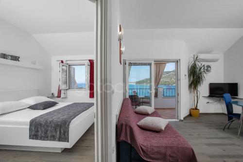 a bedroom with a bed and a view of the ocean at BeachView Apartments in Drasnice in Drašnice