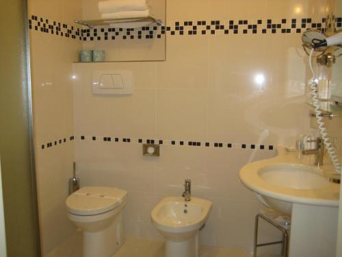 a bathroom with a toilet and a sink at Zanhotel Centergross in Bentivoglio