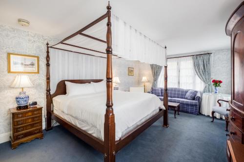 a bedroom with a canopy bed and a couch at Simsbury 1820 House in Simsbury