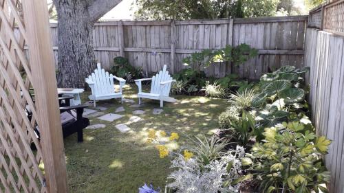a garden with two white chairs and some plants at Quiet location ,central to city in Hamilton