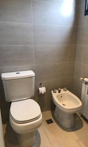 a bathroom with a white toilet and a sink at Complejo Del Este Suites in San Carlos de Bariloche