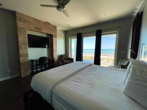 a bedroom with a large bed with a view of the ocean at 5 BEDROOM BEACHFRONT CONDO - 2nd Floor in South Padre Island