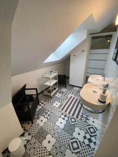 a bathroom with a tile floor with a sink and a table at Appartement hyper centre cathédrale avec parking gratuit in Amiens