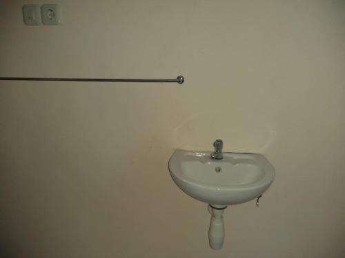 a white sink in a bathroom with a bar on the wall at Nadyah Syariah Homestay in Ketapang