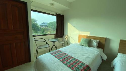 a bedroom with a bed and a table and a window at Ina Boutique Home Nan in Nan