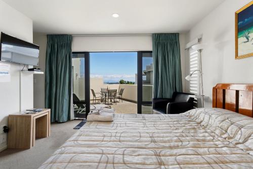 a bedroom with a bed and a view of the ocean at Studio 28 in Taupo