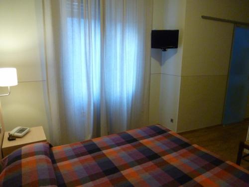a bedroom with a bed and a table with a phone at Hotel Da Cesare in Stresa