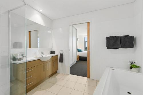 a bathroom with a tub and a sink and a mirror at Wallaroo Marina Sea Vu Apartment in Wallaroo