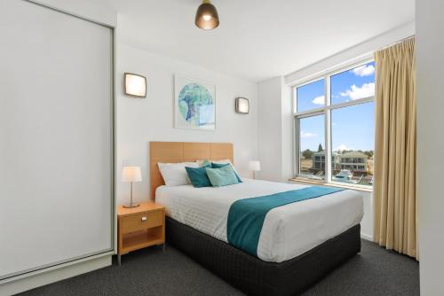 a bedroom with a bed and a large window at Wallaroo Marina Sea Vu Apartment in Wallaroo