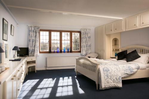 a bedroom with a bed and a desk and a window at Iffin Farmhouse in Canterbury