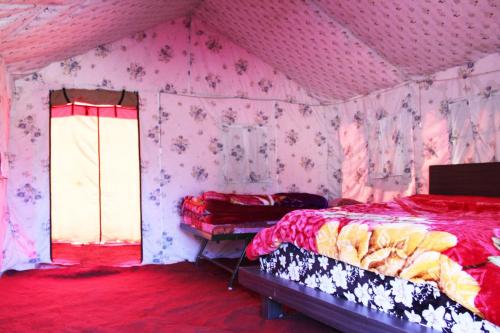 a bedroom with a bed in a room with pink walls at Chopta Mount Holiday Camp & Resort in Ukhimath
