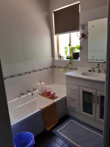 een badkamer met een bad, een wastafel en een bad bij Mundaring Bed and Breakfast in Mundaring