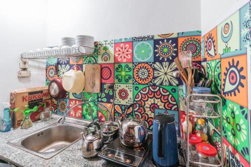 a kitchen with a sink and a colorful tile wall at Lumos Home Ha noi in Hanoi