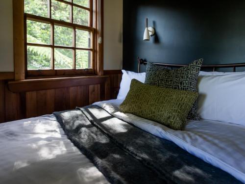 Una cama con almohadas verdes en un dormitorio en Cedar Cottage Meander, en Meander