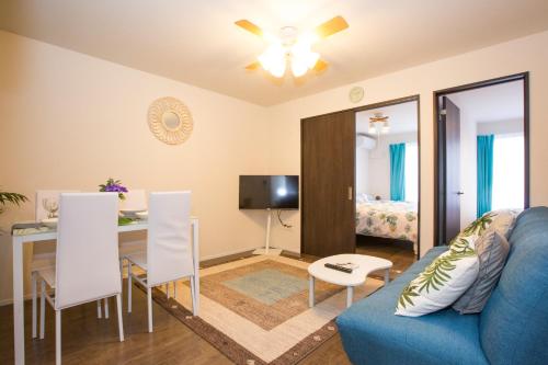 a living room with a blue couch and a table at ヒルトップ箱根入生田202 in Odawara