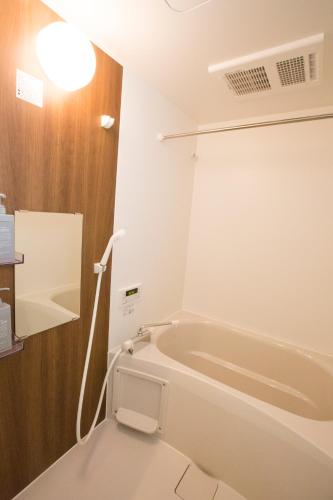 a bathroom with a bath tub and a light at ヒルトップ箱根入生田202 in Odawara