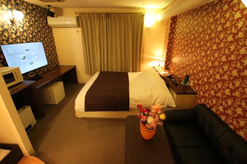 a hotel room with a bed and a couch at ホテル シンドバッド滝沢店 Adult Only in Barajima