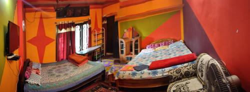 een kamer met 2 bedden in een speelkamer bij Dekapara Airport Guest House in Kāhārpāra