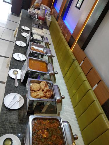 a long table with a long buffet of food at Hotel Royal Shelter in Vapi