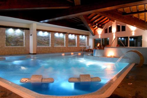 a large swimming pool in a building with at Gaarten Hotel Benessere Spa in Gallio