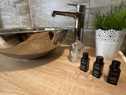 a bathroom sink with three bottles of essential oils on a counter at Loft Osijek in Osijek