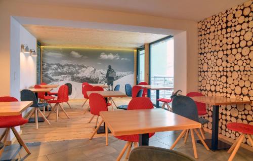 a restaurant with tables and chairs and a wall of logs at Dom Górski in Karpacz