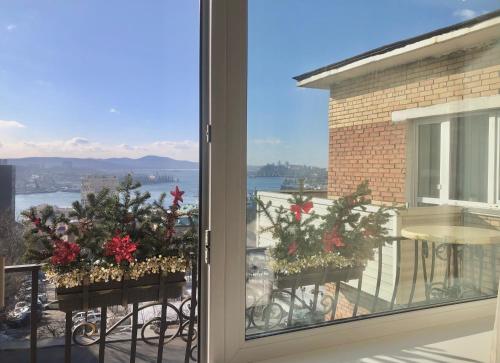 a window with christmas decorations on a balcony at Golden Bridge View Apt in Vladivostok