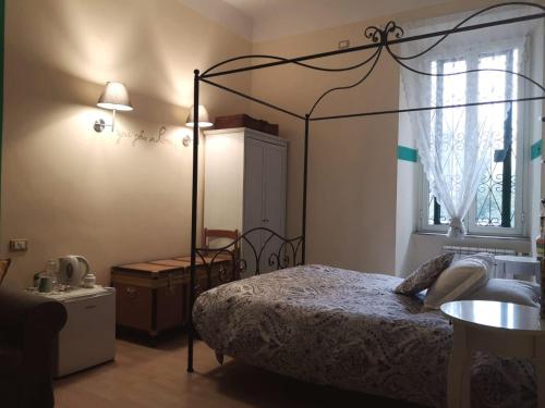 a bedroom with a canopy bed and a sink at Relais Villa Fiorelli in Rome